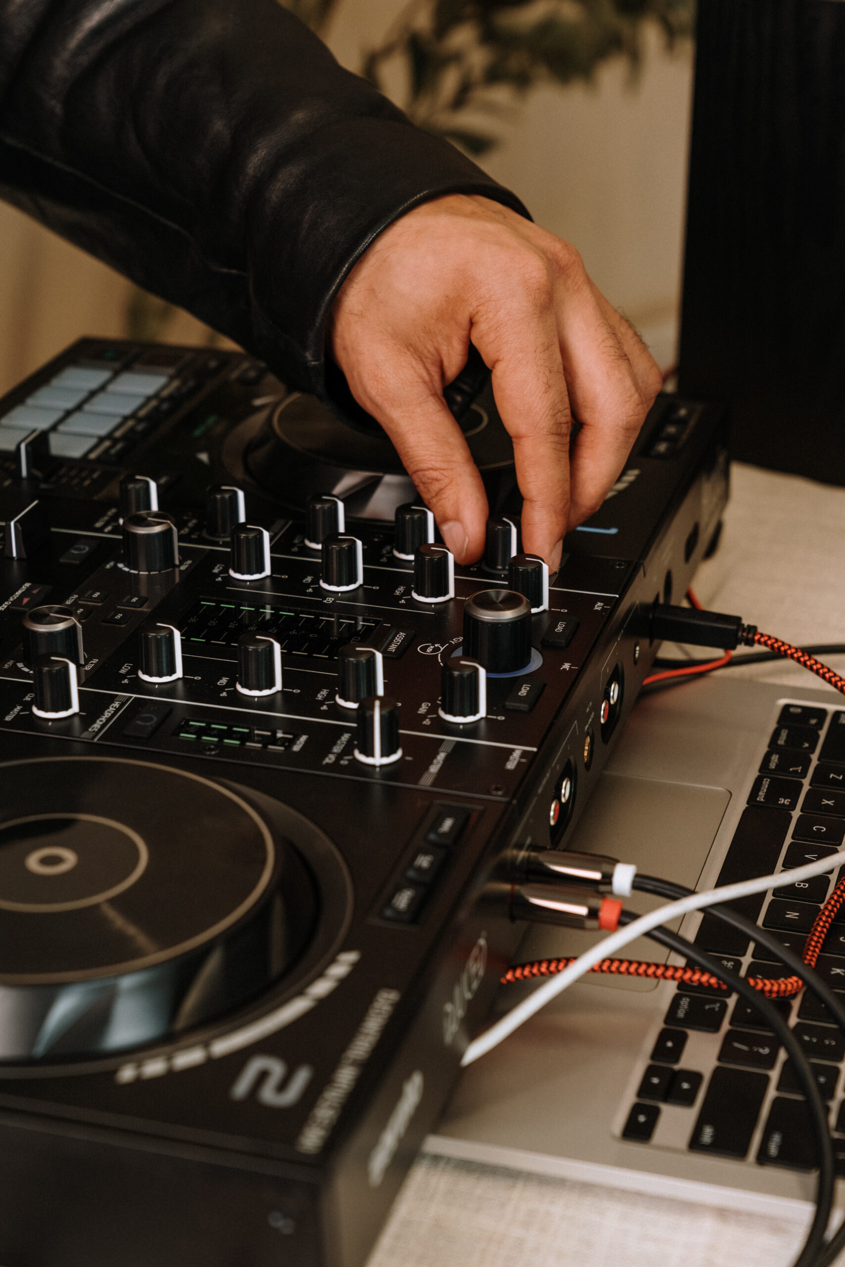 DJ adjusting the Hercules Inpulse 500 mixer and EQ controls